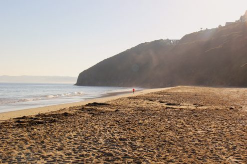 Runner on Carbis Bay beach at sunrise.
