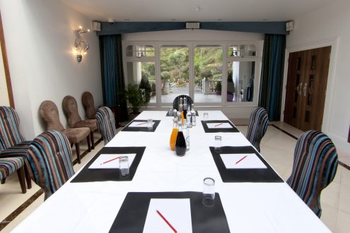 Meeting table with foliage visible through window.