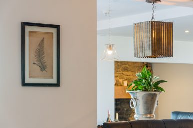 Plant on counter top next to wall with painting.