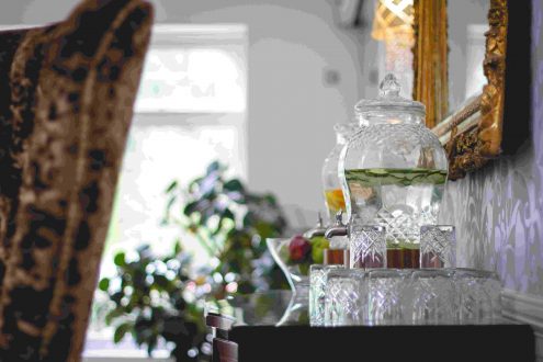 Infused water dispensers with window in background.