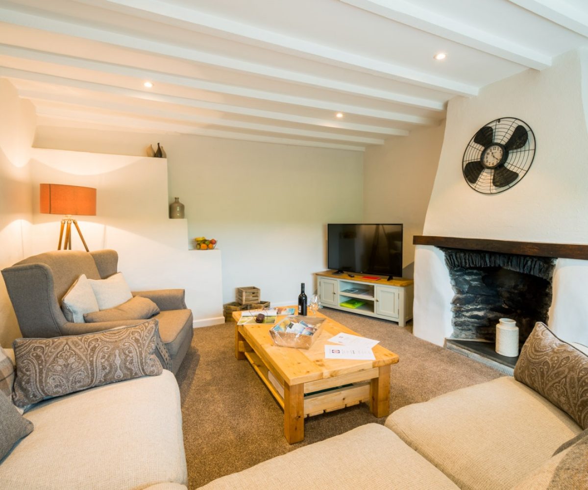 Living room with low ceilings and fireplace.