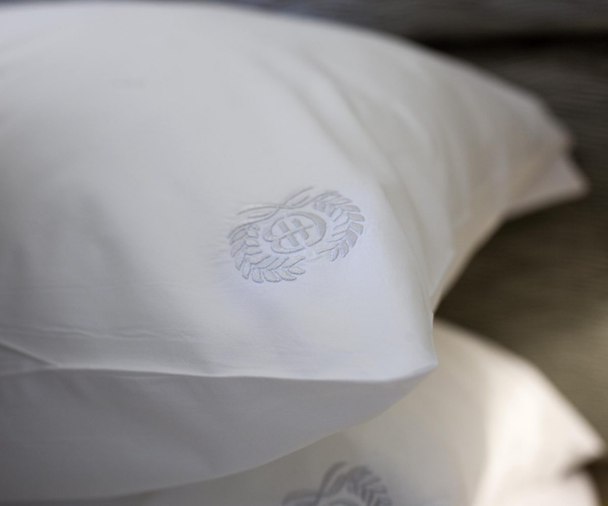 Close up of white cushion with emblem.