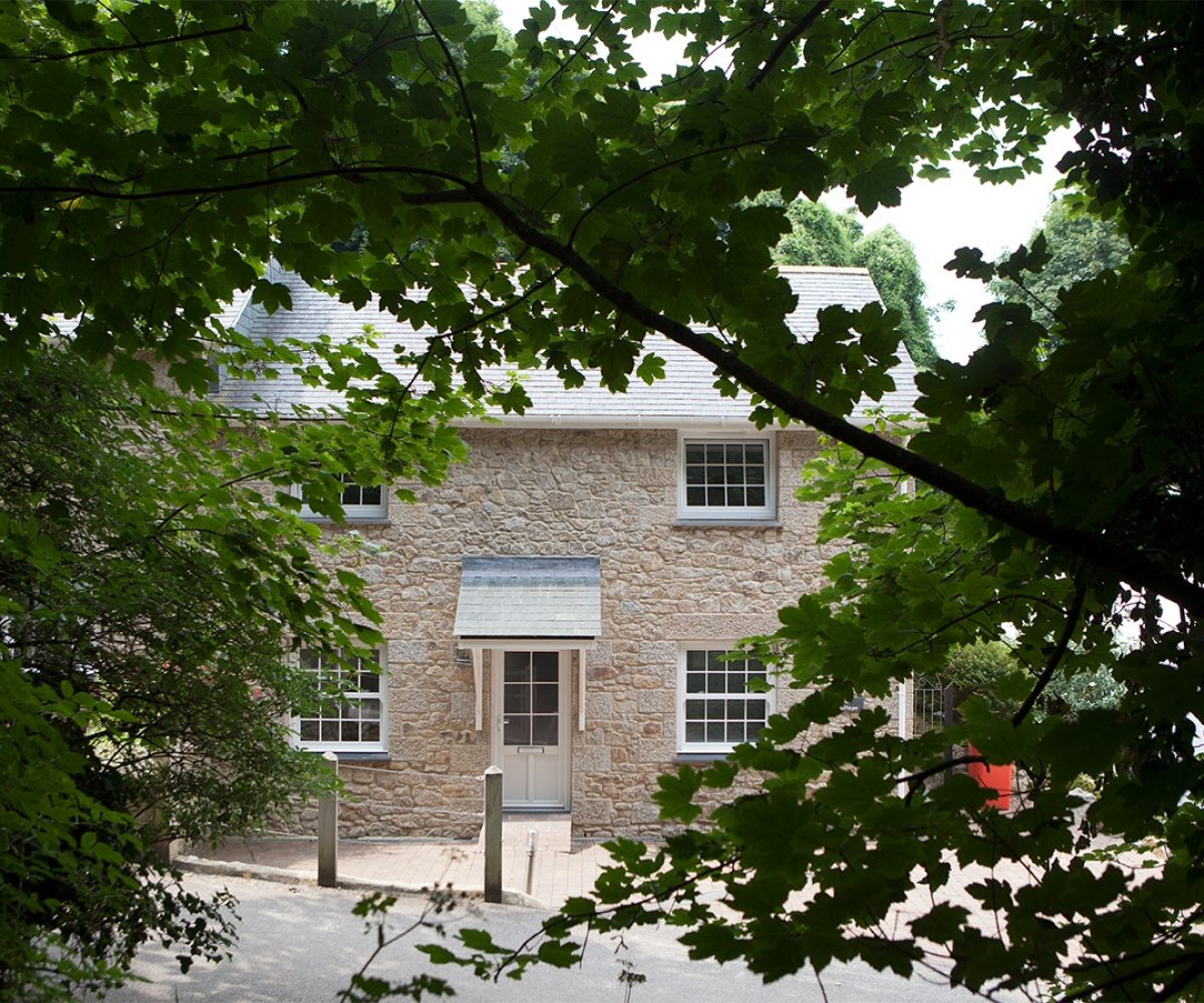 Gap in trees showing cottage.