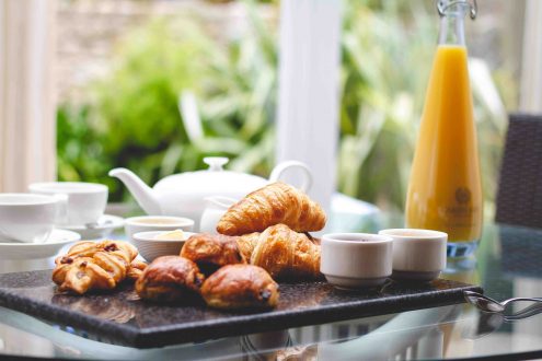 Food set up on table in front of windows.