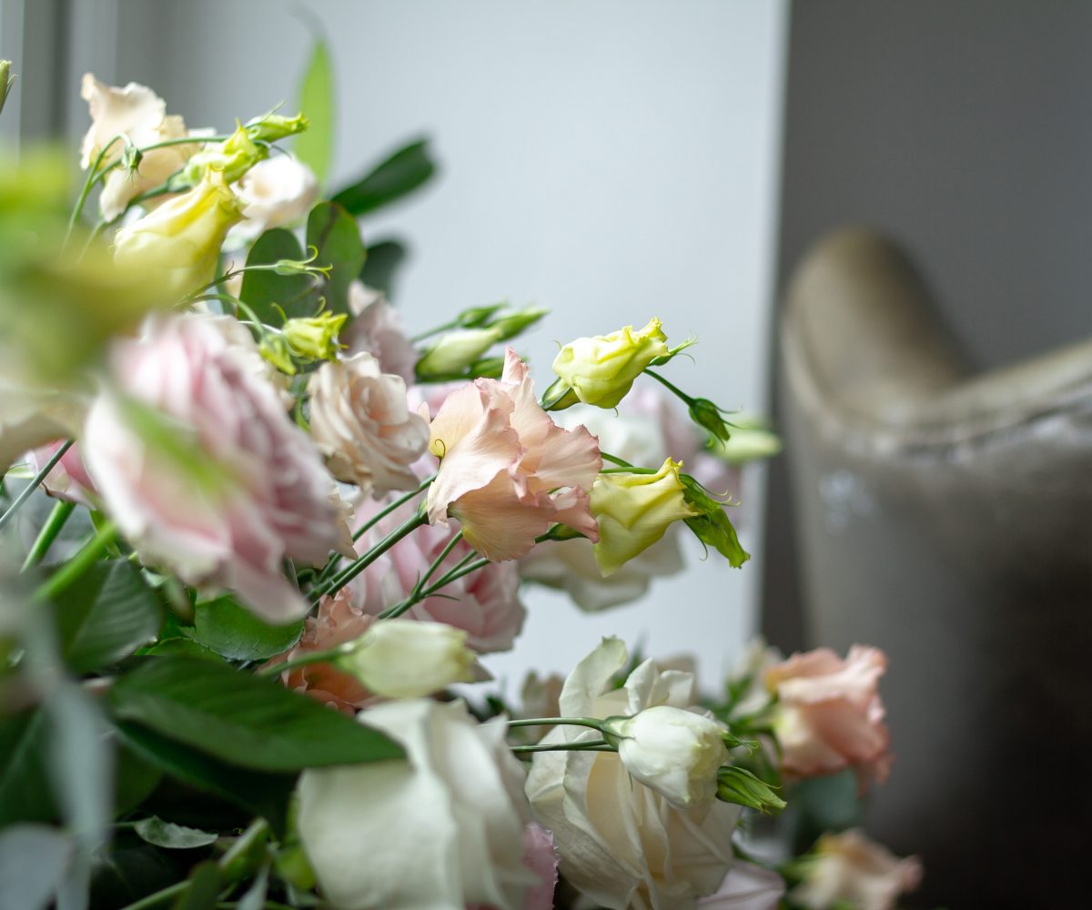 Wedding flowers with armchair in background.