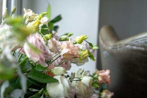 Wedding flowers with armchair in background.