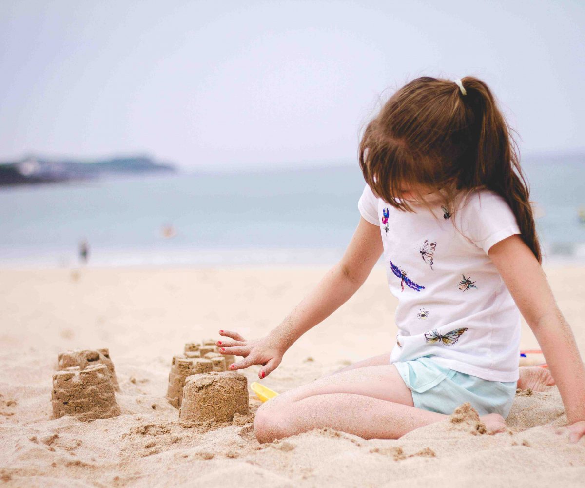 Young girl building sandcastles.
