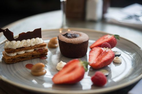 Chocolate dessert on plate with strawberries.